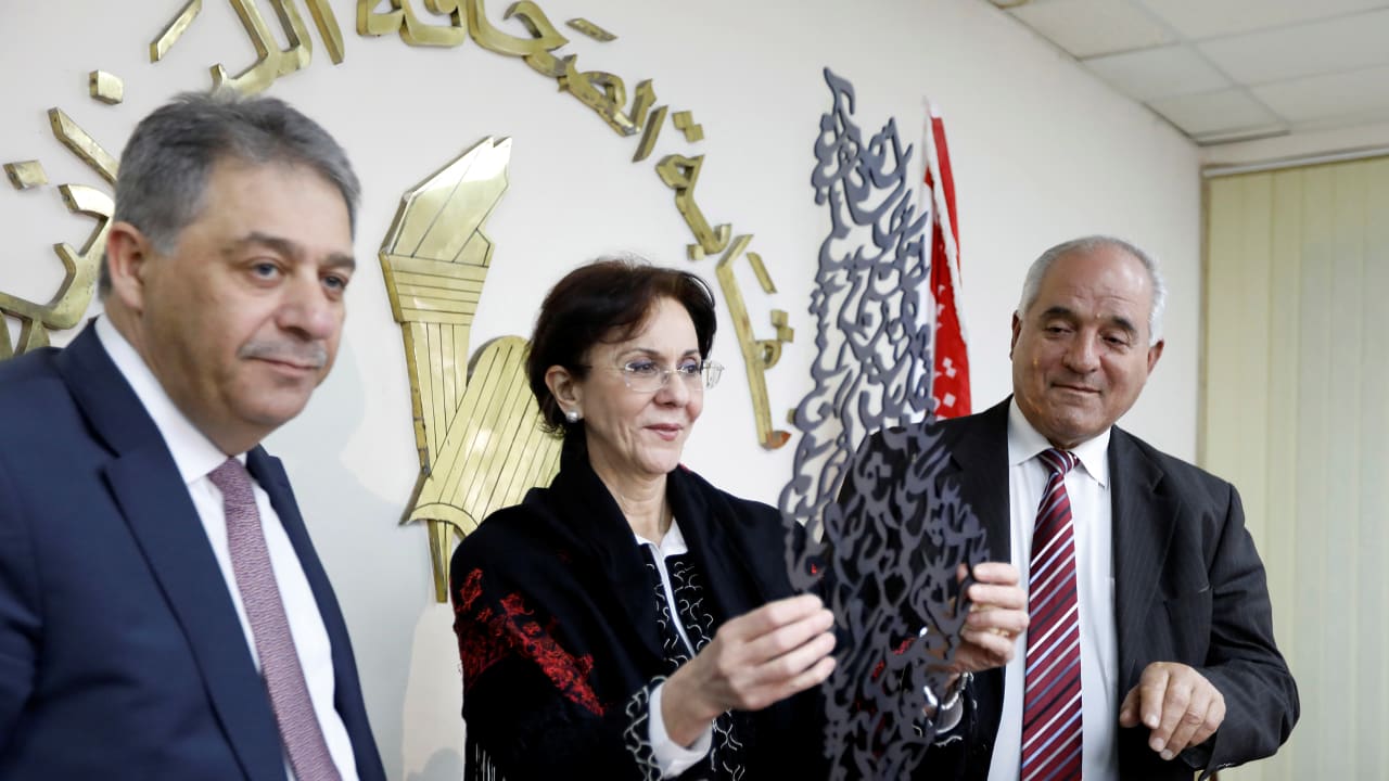 Palestinian Ambassador to Lebanon Ashraf Dabbour (L) stands next to U.N. Under-Secretary General and ESCWA Executive Secretary Rima Khalaf (C) while she holds a gift, an Arabic calligraphy that reads "All the world is Palestine."