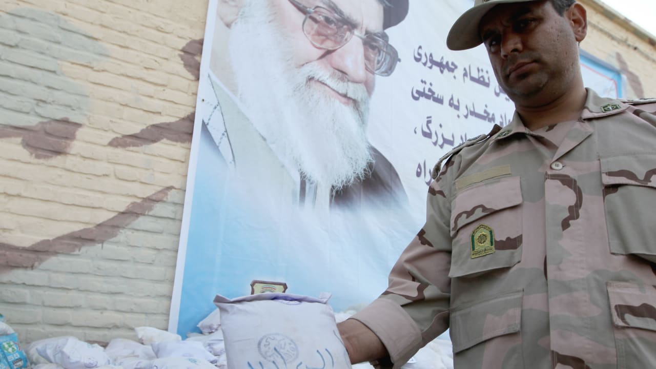 An Iranian policeman holds up a package of seized Afghan-made drugs during a media tour in the southeastern city of Zahedan, on July 19, 2011; illustrative