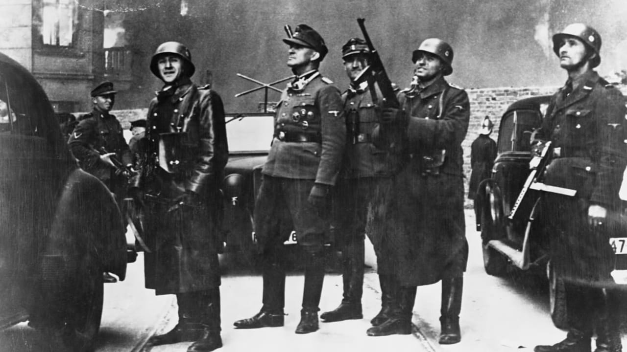 Jürgen Stroop watches his troops raze the Warsaw Ghetto.