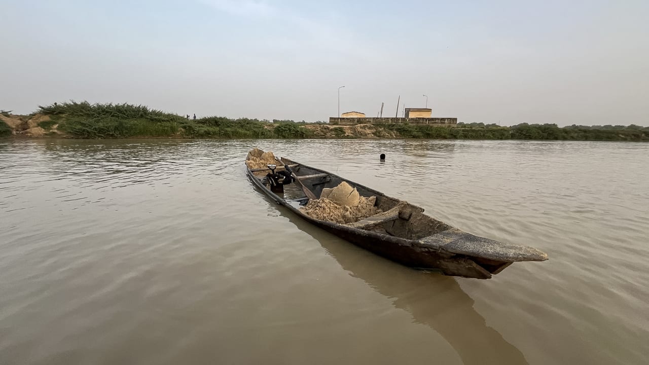 Men extract sand used for construction from the Sokoto river and place it on their boat in Argungu in northern Nigeria, on April 11, 2025