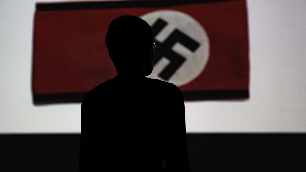A man looks at a Nazi flag as he visits the exhibition "Design of the Third Reich" at the Design Museum Den Bosch in 's-Hertogenbosch; illustrative.
