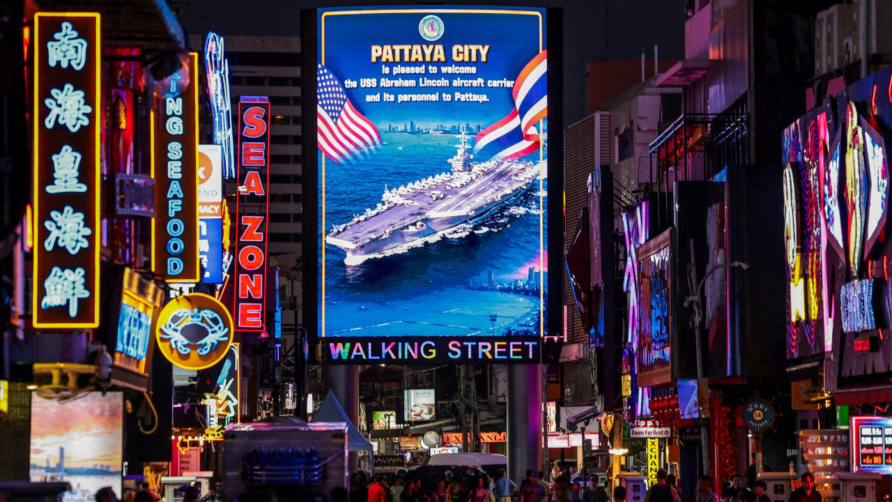 People walk past an LED display welcoming U.S. service personnel from the U.S. Nimitz-class aircraft carrier USS Abraham Lincoln, which is docked at Laem Chabang Port for a rest stop following a long deployment in the Middle East, in Pattaya City, Thailand, September 3, 2026.