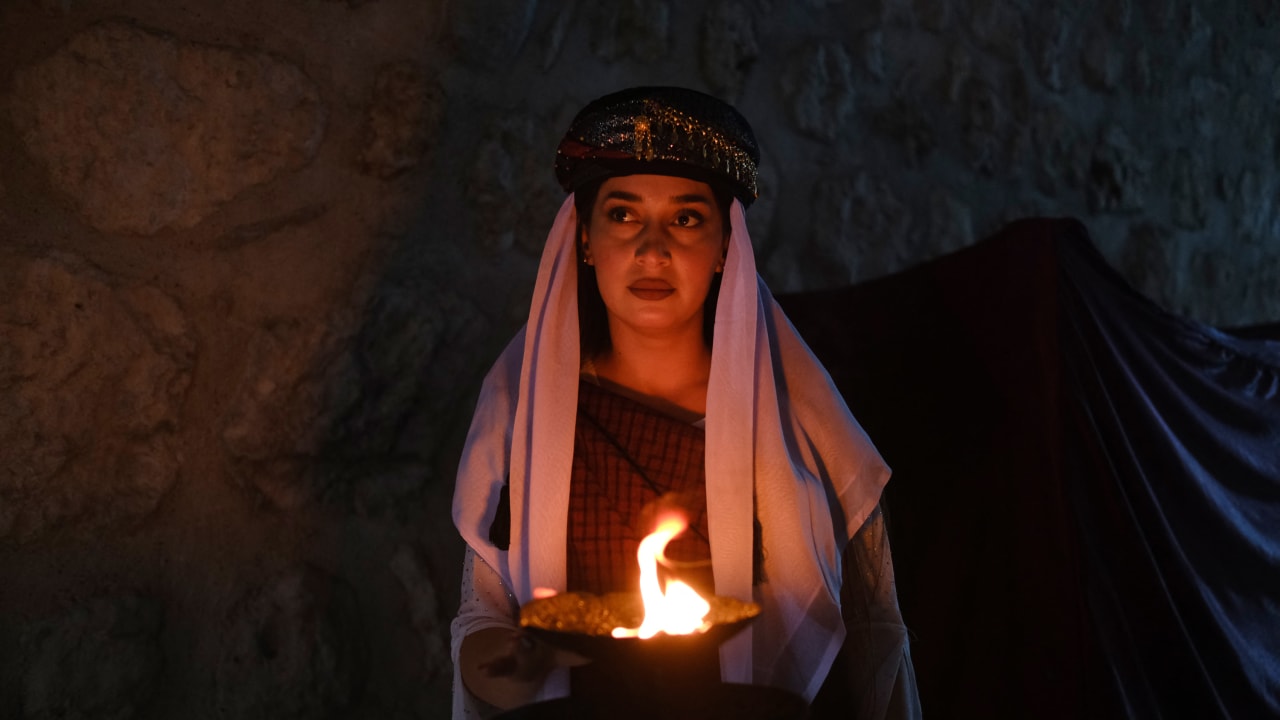 A Yazidi woman holds a candle during a ceremony marking Charshama Sor, or Red Wednesday, the Yazidi New Year, at Lalish temple in Shaikhan near Dohuk in northern Iraq on April 14, 2026. Northern Iraq's Kurdistan Region is home to the Yazidi religious minority.