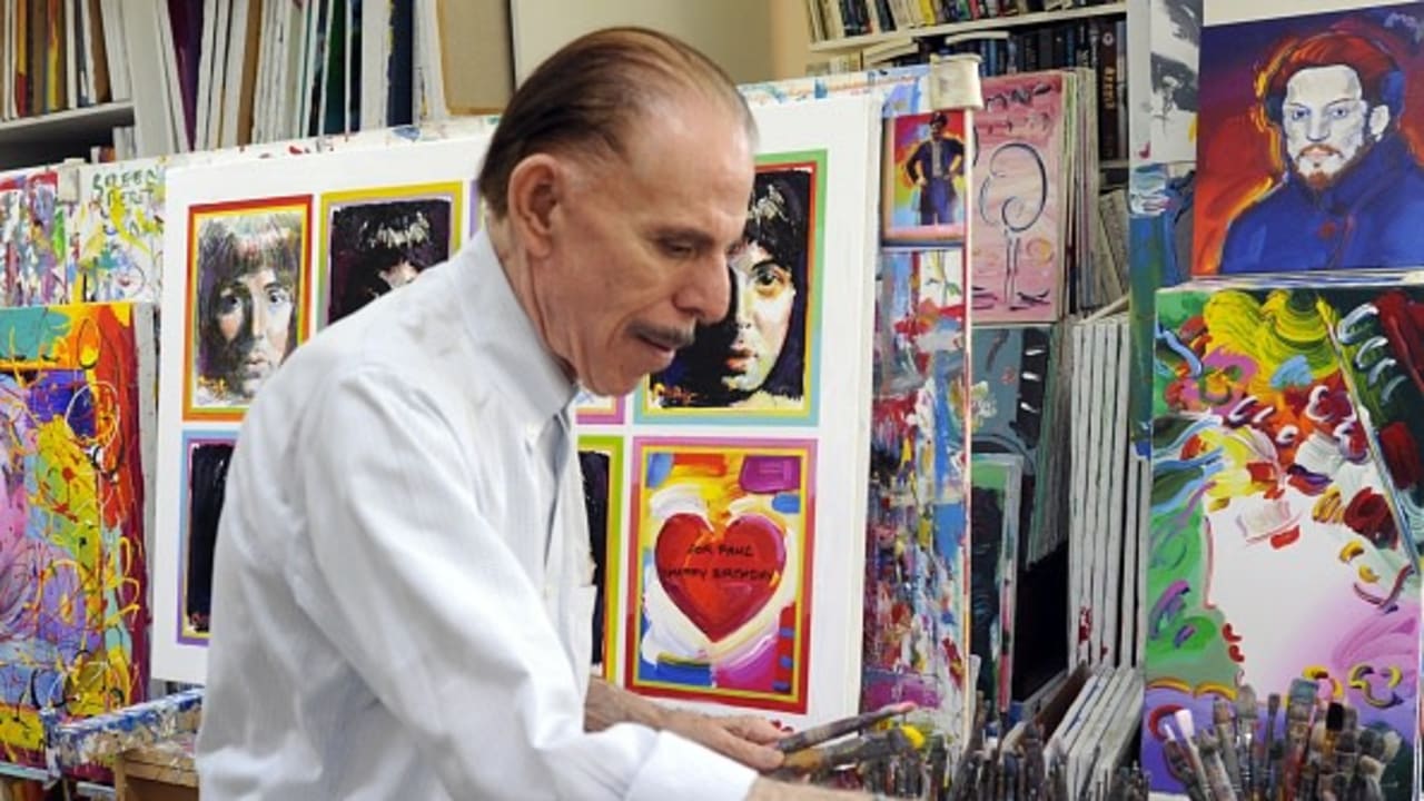 Pop artist Peter Max poses in his New York studio on June 18, 2012 with seven portraits he created of Sir Paul McCartney to commemorate McCartneys 70th birthday.