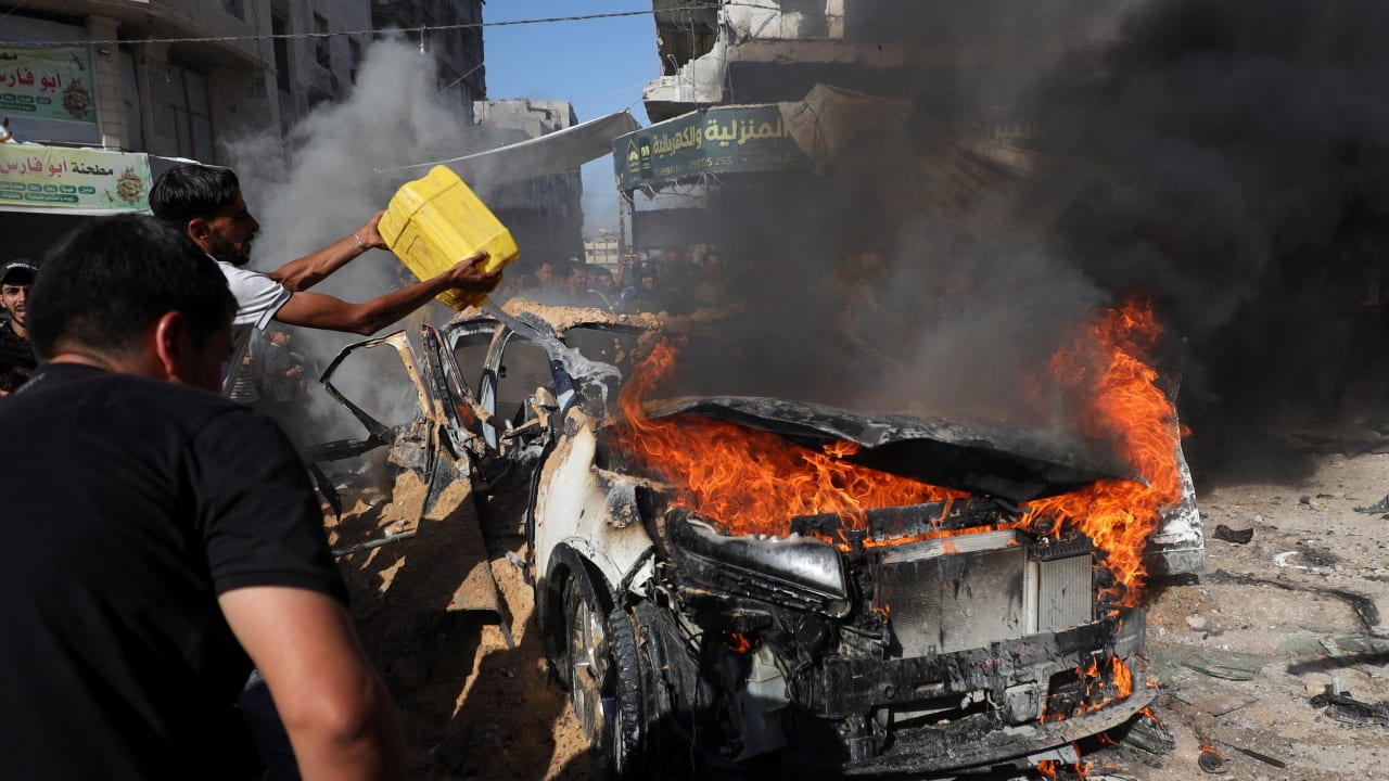 Palestinians attempt to extinguish a fire following an Israeli air strike that hit a vehicle in Gaza City, September 19, 2026.