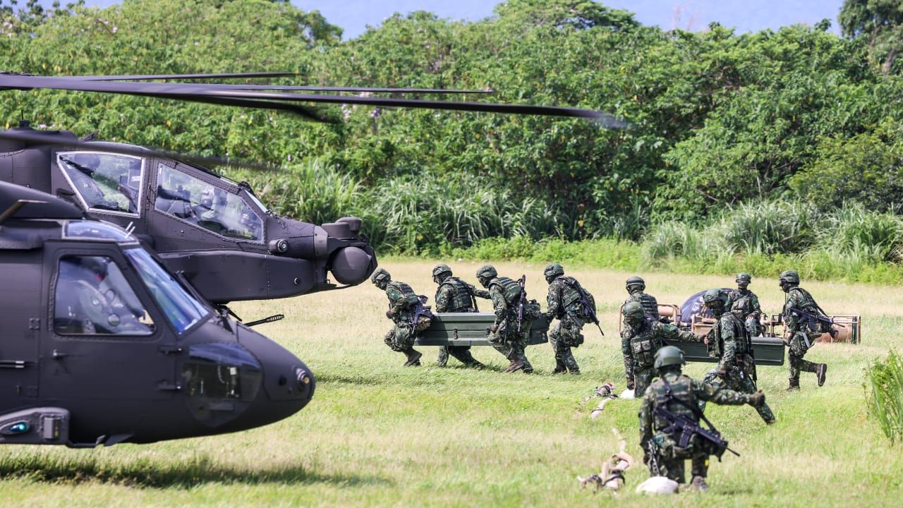 Taiwanese soldiers carry fuel supplies towards AH-64E Apache Guardian and UH-60M Black Hawk helicopters during a refueling drill as part of the annual Han Kuang military exercise in Taoyuan on August 11, 2026