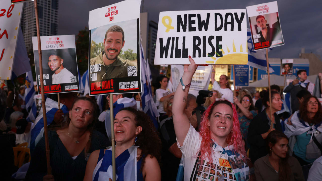 People holding up portraits of Israeli hostages still held in Gaza gather at Hostage Square in Tel Aviv in October 2025. 