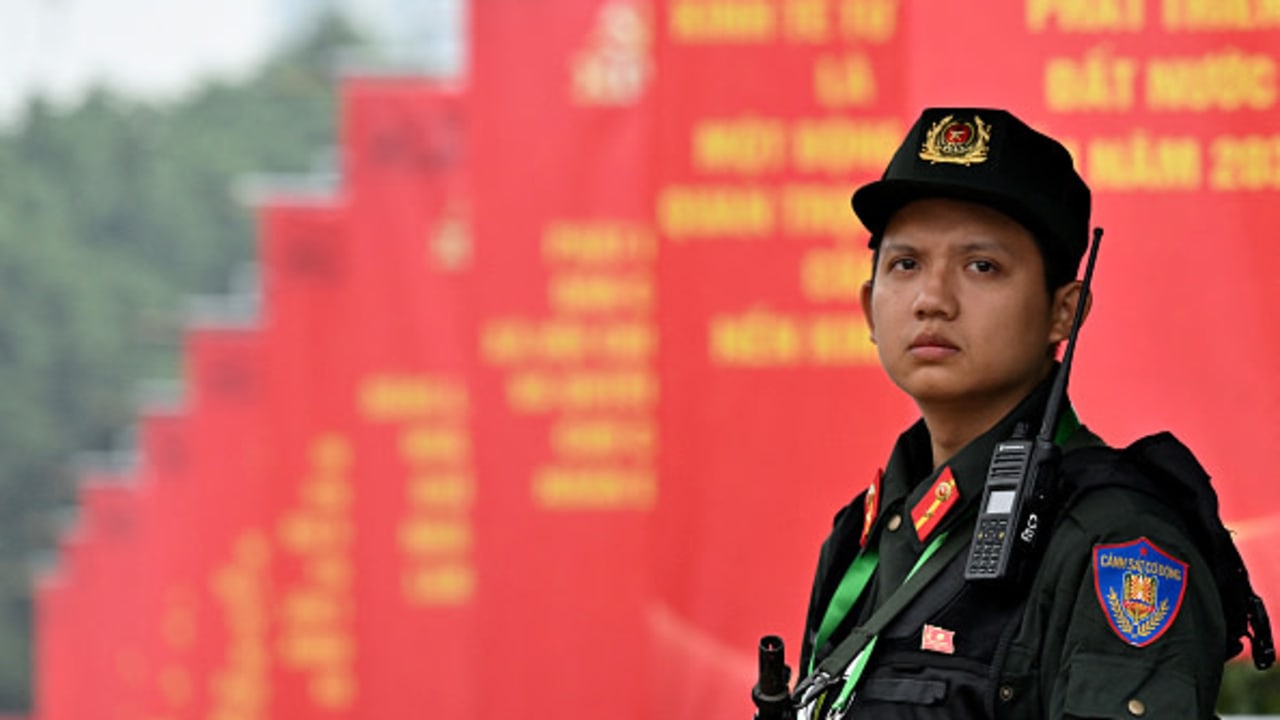 A police officer stands in front of posters for the 14th Congress of the Communist Party of Vietnam outside the National Convention Center in Hanoi on January 19, 2026. 