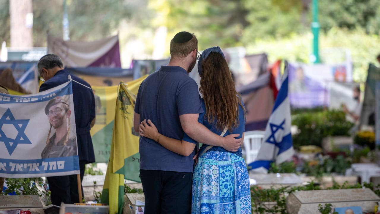 A couple embrace at the Mt Herzl military cemetery, at the section with victims killed in the October 7 Hamas attack, October 05, 2026. 