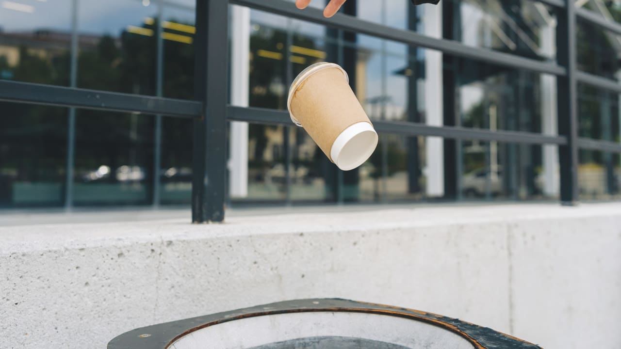 He could throw the empty cup out the window, thinking no one will notice.