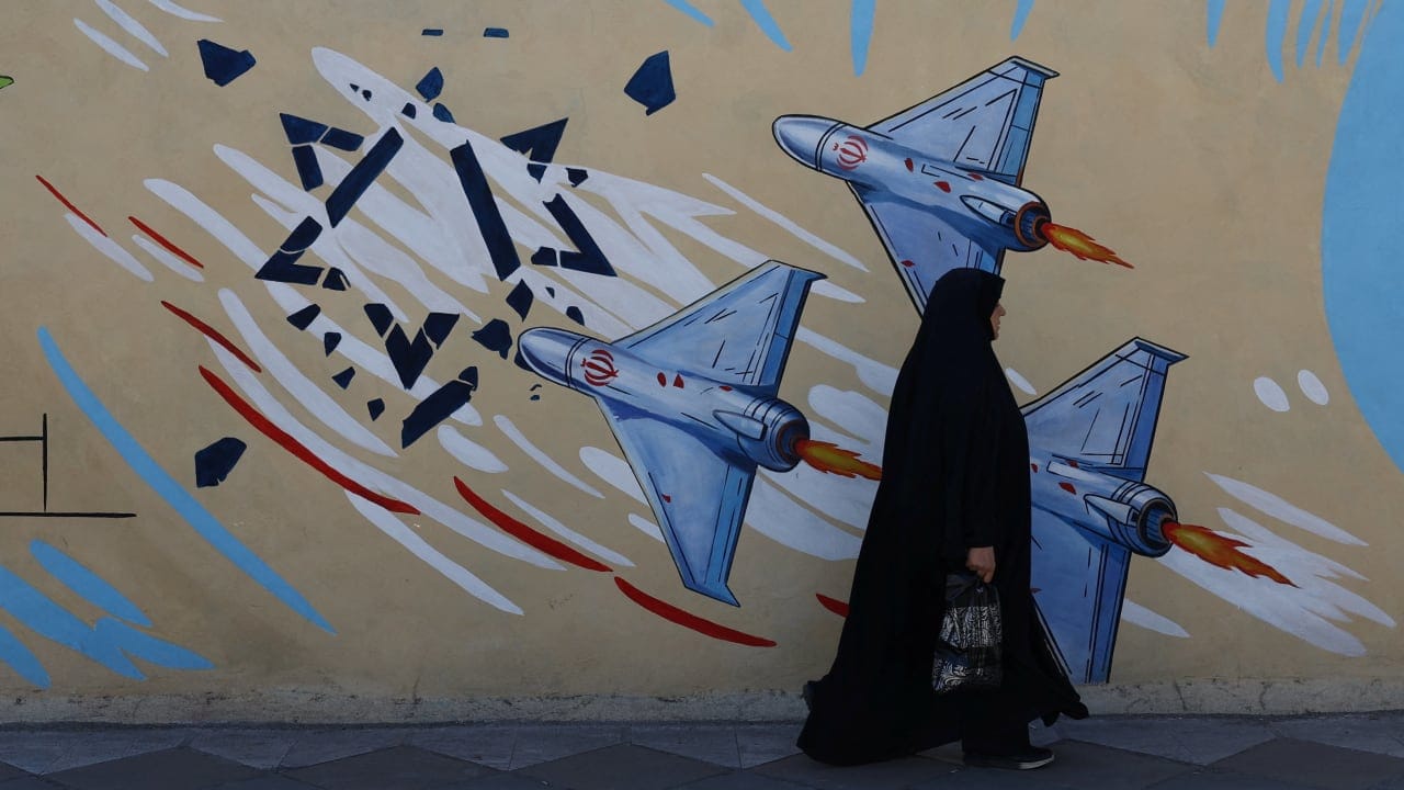 An Iranian woman walks next to an anti-Israeli mural on a street in Tehran, Iran, May 18, 2026.