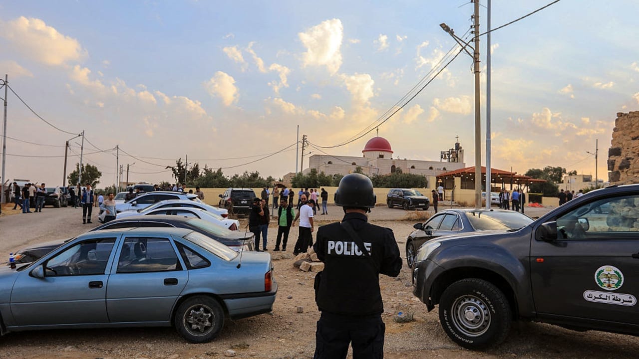 People and security forces gather outside a Greek Orthodox Church in the village of Hammoud in Jordan's Karak governorate following a shooting on October 23, 2026. 