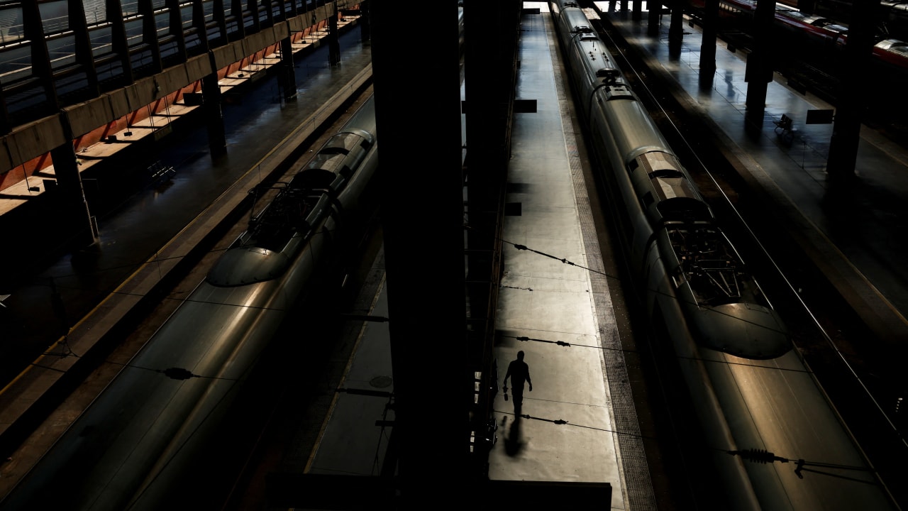 A worker walks on an empty platform next to trains following the collision of two high-speed trains between the towns of Mora and Orgaz, at Atocha train station in Madrid, Spain, October 28, 2026.