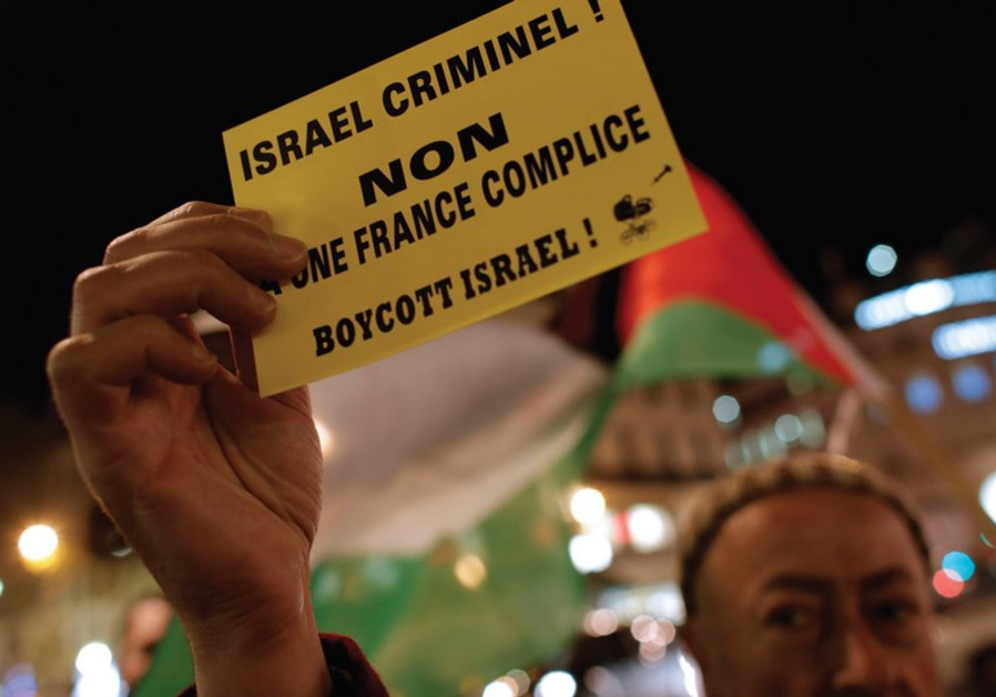 A PALESTINIAN supporter holds a protest leaflet advocating a boycott of Israel in France