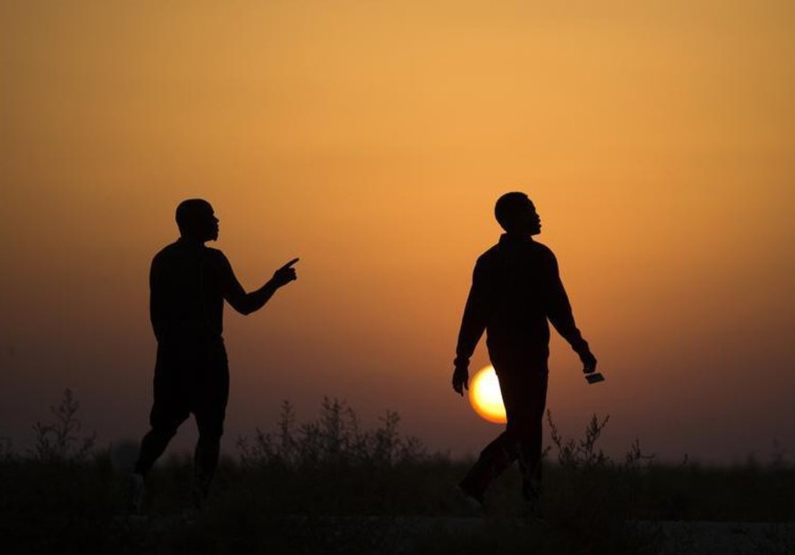 African migrants walk outside Holot open detention center in Israel's southern Negev desert
