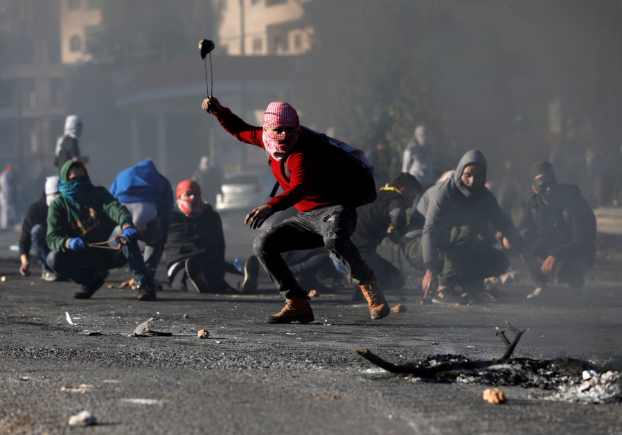 Protestors hurl stones at police near Ramallah (credit: Mohamad Torokman/ Reuters)