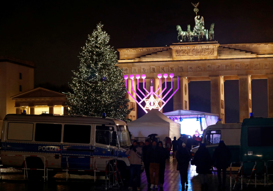 Europe’s largest Hanukkah menorah is seen next to a Christmas tree during the lighting ceremony at the Brandenburg Gate in Berlin, Germany, December 12, 2017. / FABRIZIO BENSCH / REUTERS 