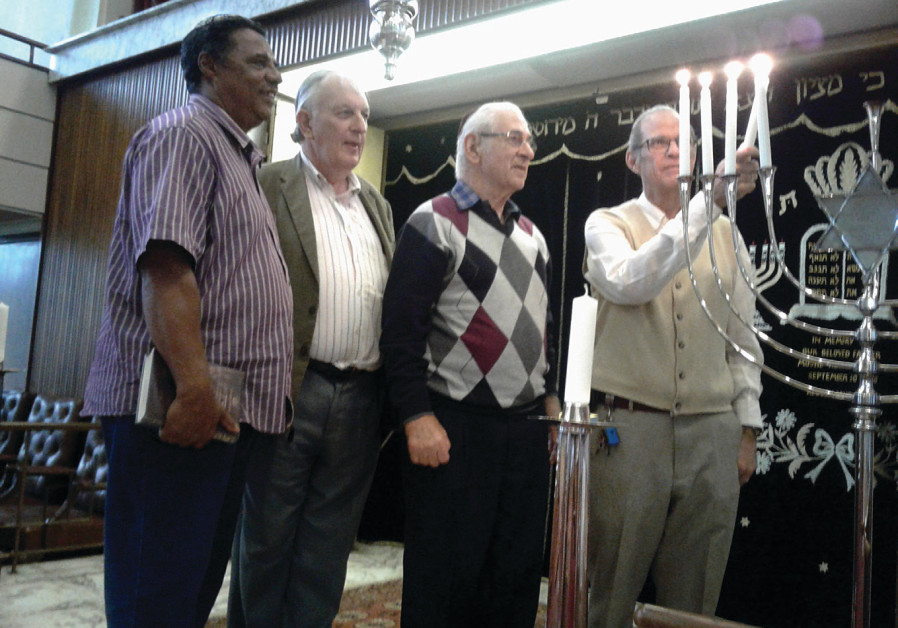 Hanukka at Shaare Shalom: (L- R) Dean Moody, Harare Hebrew Congregation President Arnold Joffe and Benny Leon watch Victor Alhadeff (credit: Dave Bloom)