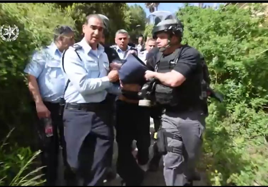 Police escort a suspect who wielded a handsaw and attacked officers and elderly Israelis at a Haifa hospital, March 2018 (credit: screenshot)