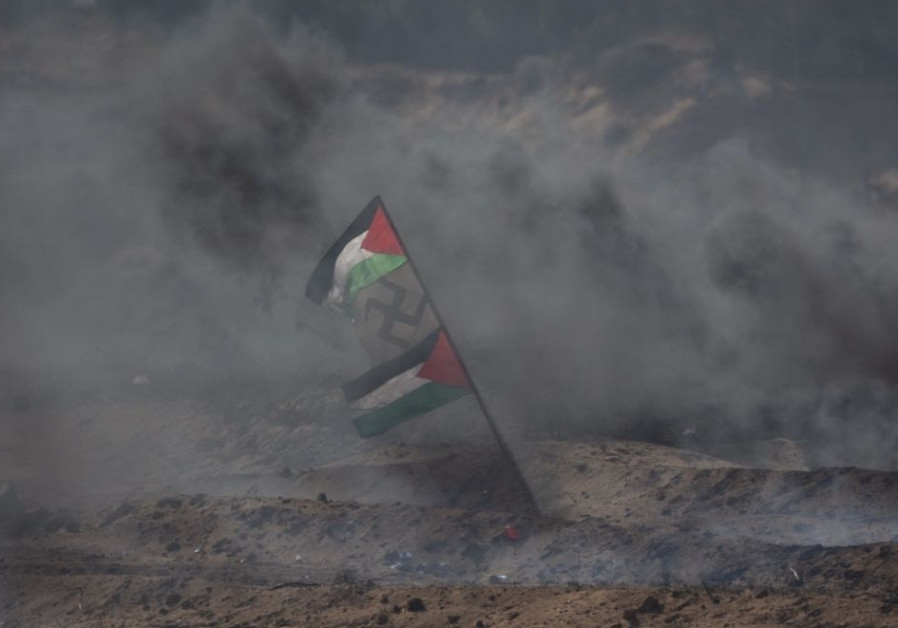 Palestinian flags flank a swastika in the midst of smoke during protests in Gaza (credit: IDF Spokesperson's Unit)