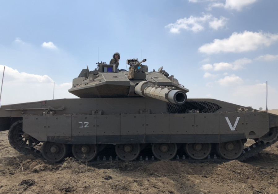 A soldier sits atop an IDF Merkava tank during a drill in Israel's north 