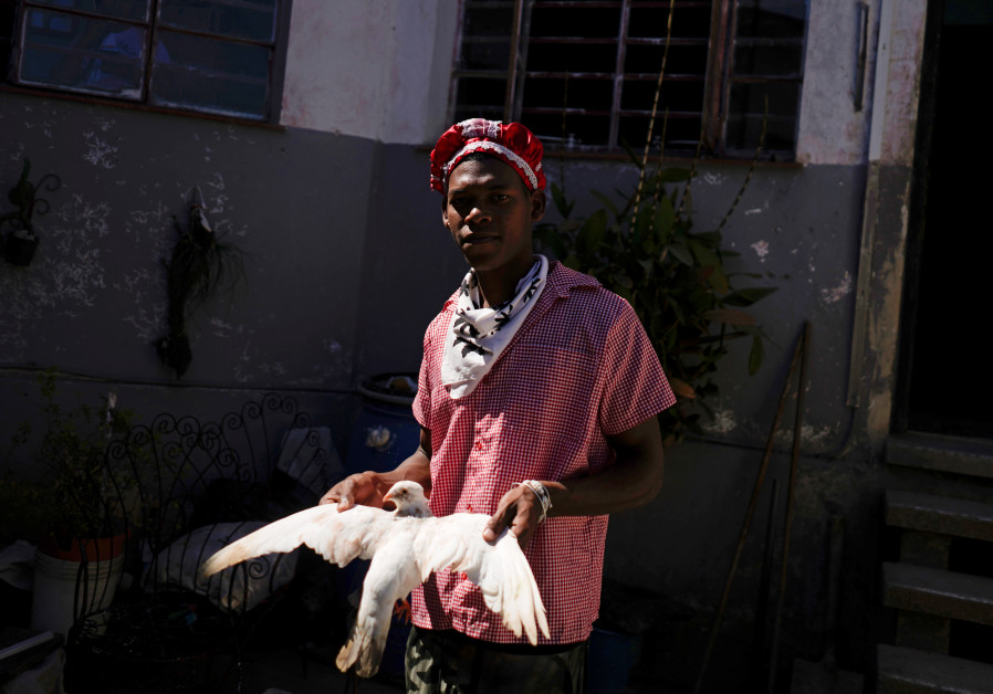 Follower of the Afro-Cuban religion Santeria holds a dove during a ceremony amid concerns about the spread of the coronavirus disease outbreak in Havana