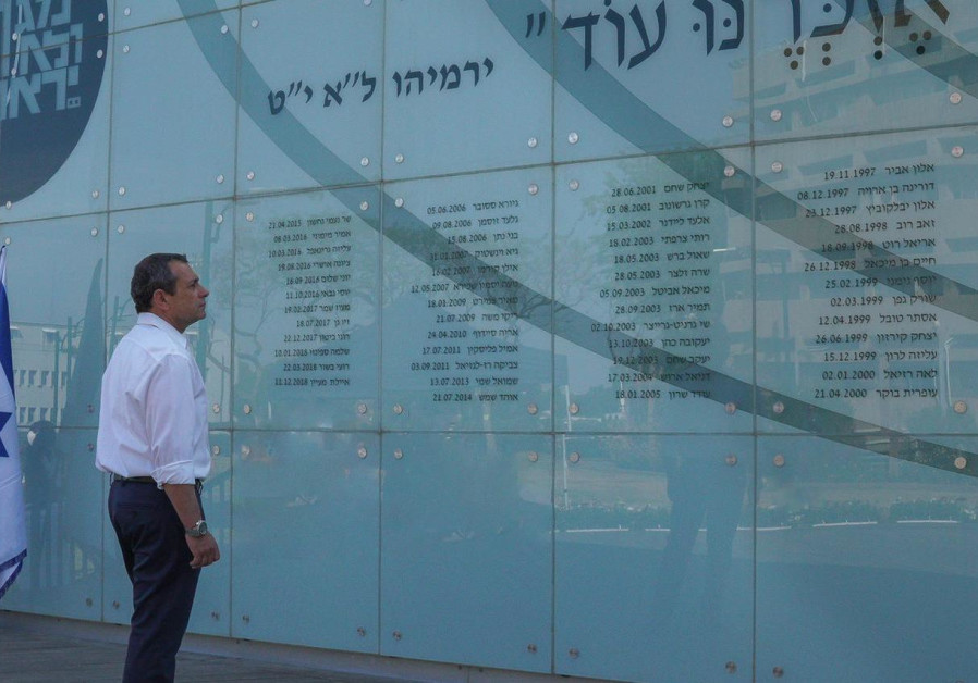 Shin Bet Chief Nadav Argaman stands in front of the wall of fallen servicepeople at Shin Bet headquarters. (Shin Bet)