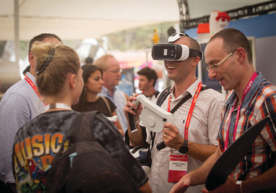 PARTICIPANTS AT the DLD Tel Aviv Digital Conference, Israel’s largest international hi-tech gathering, featuring hundreds of start ups, VCs, angel investors and leading multinationals, get hands-on with some tech. (Credit: Miriam Alster/Flash90)