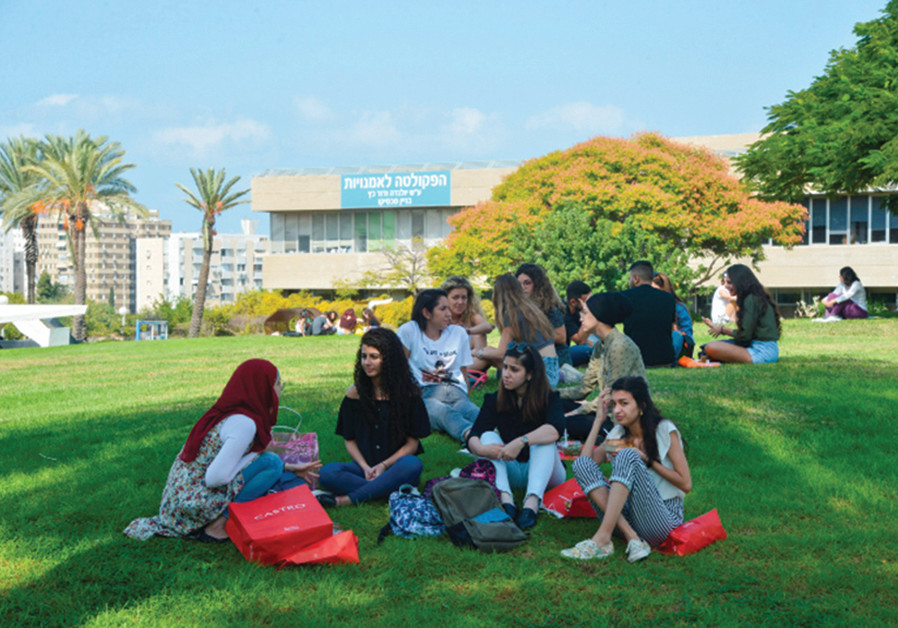 THE MODEL of higher education will have to change’: Tel Aviv University students relax (in a decidely non-socially distant way) on the first day of the new academic year, in October 2018. (Credit: Flash90)