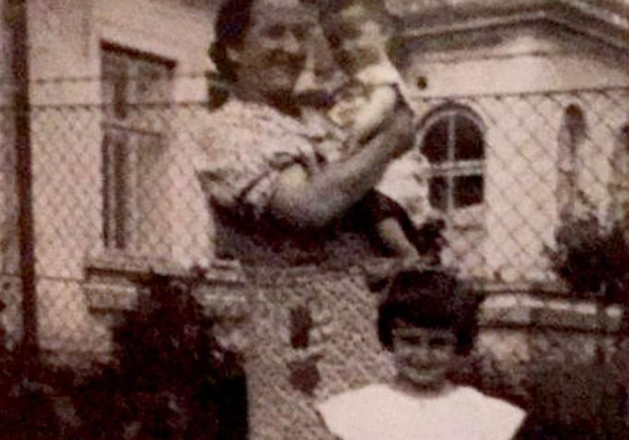 THE WRITER’S great aunt Rachel Birnbach holds her son Natan and stands with daughter Chajcia in front of their house, which still exists. (Courtesy)