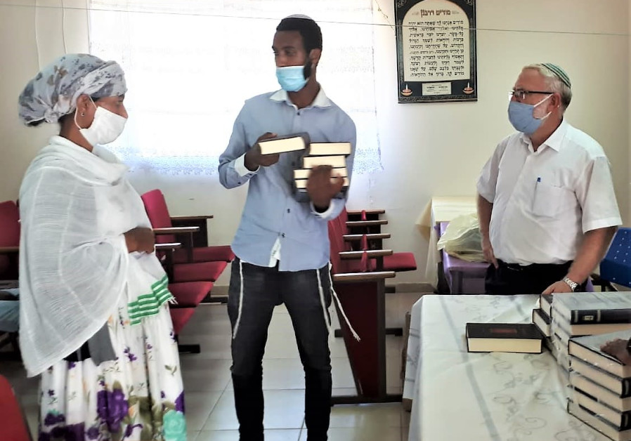 AYENEW AND his mother, brought to Israel despite the coronavirus, receive Bibles and prayer books in Amharic and Hebrew from Rabbi Menachem Waldman. (Courtesy)