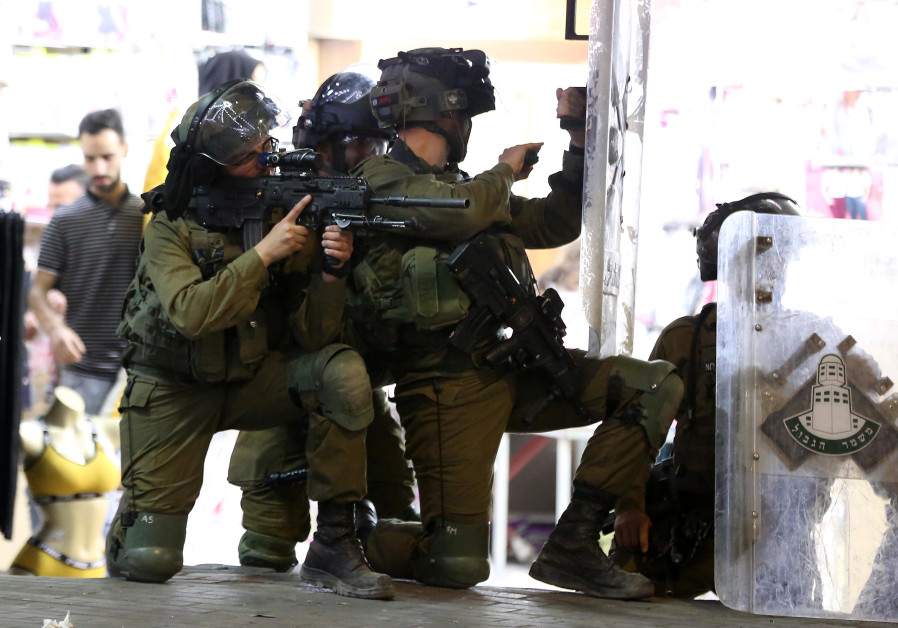 Palestijnse jongeren komen in botsing met Israëlische veiligheidstroepen tijdens een protest over de spanning in Jeruzalem, bij de Qalandia-controlepost nabij de stad Ramallah op de Westelijke Jordaanoever, 10 mei 2021. (Wisam Hashlamoun / Flash90)