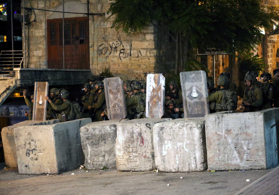 Palestijnse jongeren komen in botsing met Israëlische veiligheidstroepen tijdens een protest over de spanning in Jeruzalem, bij de Qalandia-controlepost nabij de stad Ramallah op de Westelijke Jordaanoever, 10 mei 2021. (Wisam Hashlamoun / Flash90)