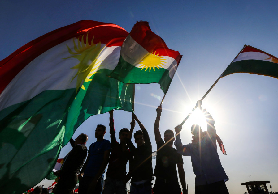 Curdos iraquianos acenam bandeiras do Curdistão iraquiano durante uma manifestação
