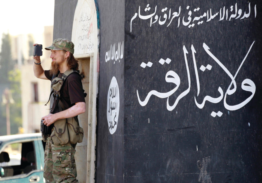 Un combattant de l'Etat islamique utilise son téléphone pour organiser un défilé militaire dans la province de Raqqa, dans le nord de la Syrie, en 2014