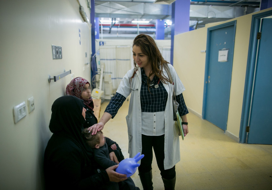 An Israeli doctor socializes with Syrian patients and their family. (Photo: Marc Israel Sellem/The Jerusalem Post)