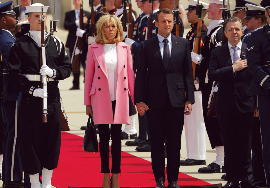 French president Emmanuel Macron and his wife, Brigitte, stand at attention for the French and US na