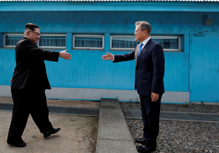 South Korean President Moon Jae-in and North Korean leader Kim Jong Un shake hands at the truce vill