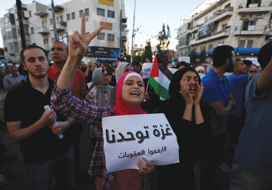 Un manifestant palestinien brandit une pancarte qui dit "Gaza nous unit" lors d'une manifestation
