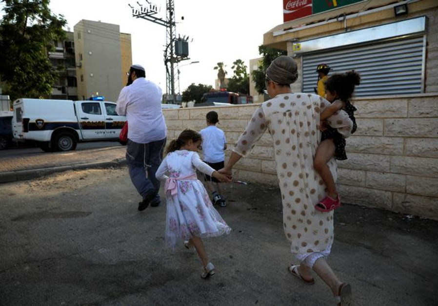 Israelis run for shelter as a siren sounds during a rocket attack at the southern city of Sderot Jul