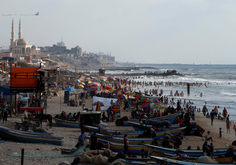 Gazans swim in the Mediterranean Sea as others enjoy their time on a beach in the northern Gaza Stri