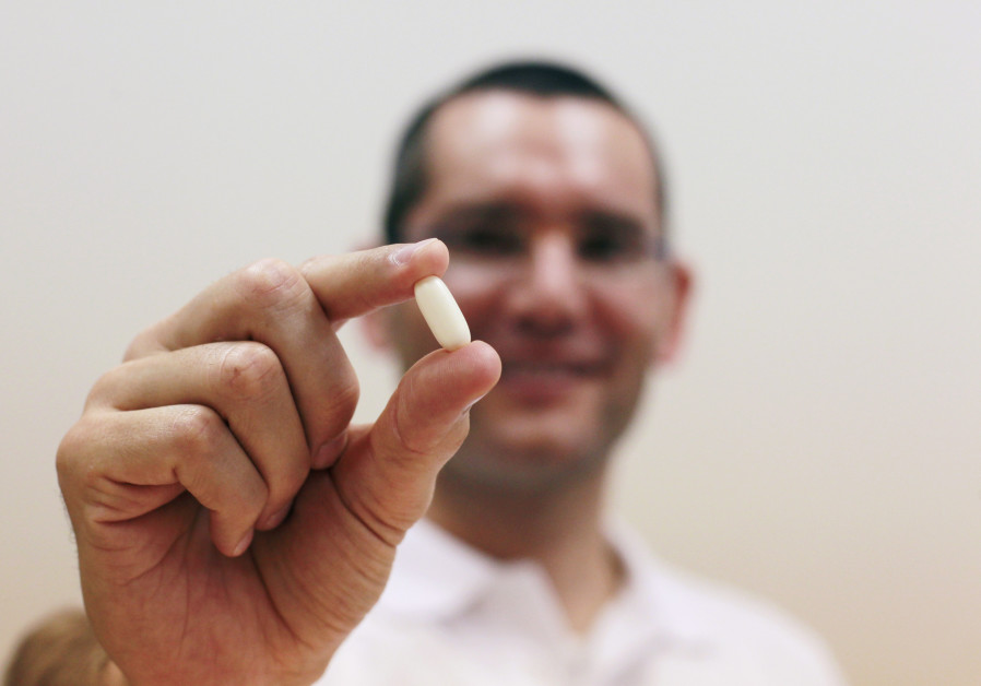 Nadav Kidron, CEO of Oramed Pharmaceuticals, shows an insulin pill as he poses for a photo