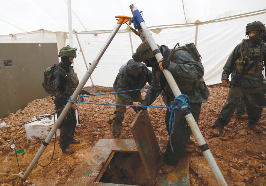 IDF SOLDIERS LIFT the cover off a hole into a cross-border tunnel dug from Lebanon into Israel, near