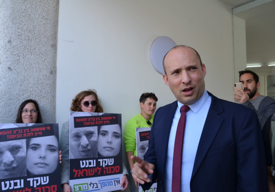Meretz supporters (background) confront Naftali Bennett (front-right) outside a press conference and call him a "danger to Israel," in Tel Aviv, March 17th, 2019 (Courtesy)