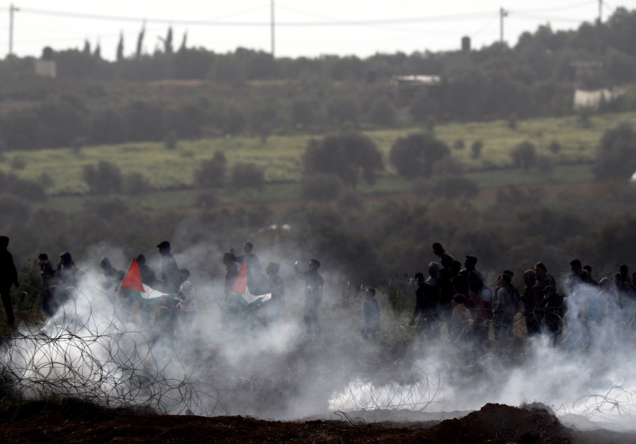 Palestinians protest next to the border fence between Israel and the Gaza Strip, March 30, 201