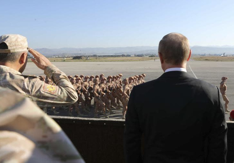 Le président russe Vladimir Poutine (R) et le ministre de la Défense, Sergei Shoigu, observant des militaires qui passent 