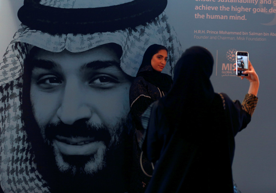  Participants take photos next to a picture of Saudi Crown Prince Mohammed bin Salman during the Mis