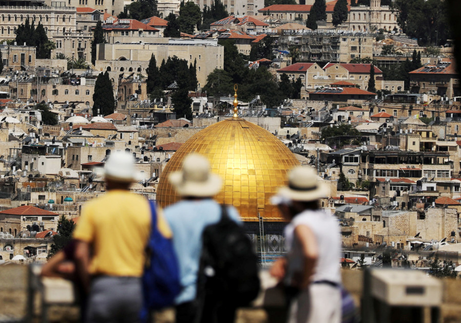 Tourists look at the Dome of the Rock, located in Jerusalem's Old City on the compound known to Musl