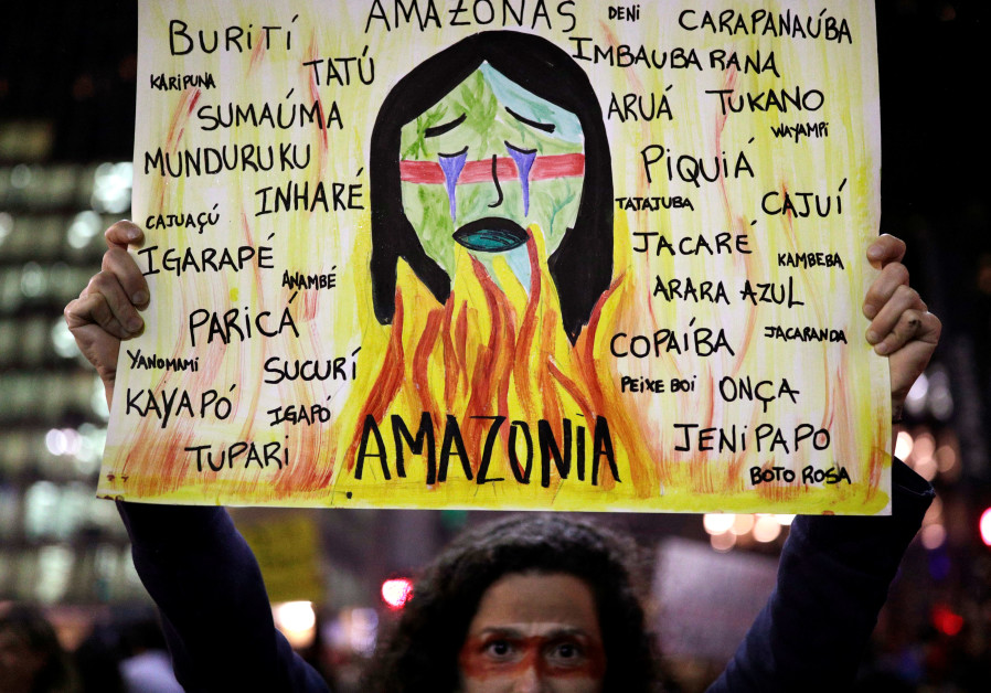 A protester holds a sign with the names of various indigenous tribes during a demonstration to demand for more protection for the Amazon rainforest, in Sao Paulo, Brazil, August 23, 2019 (NACHOS DOCE / REUTERS)