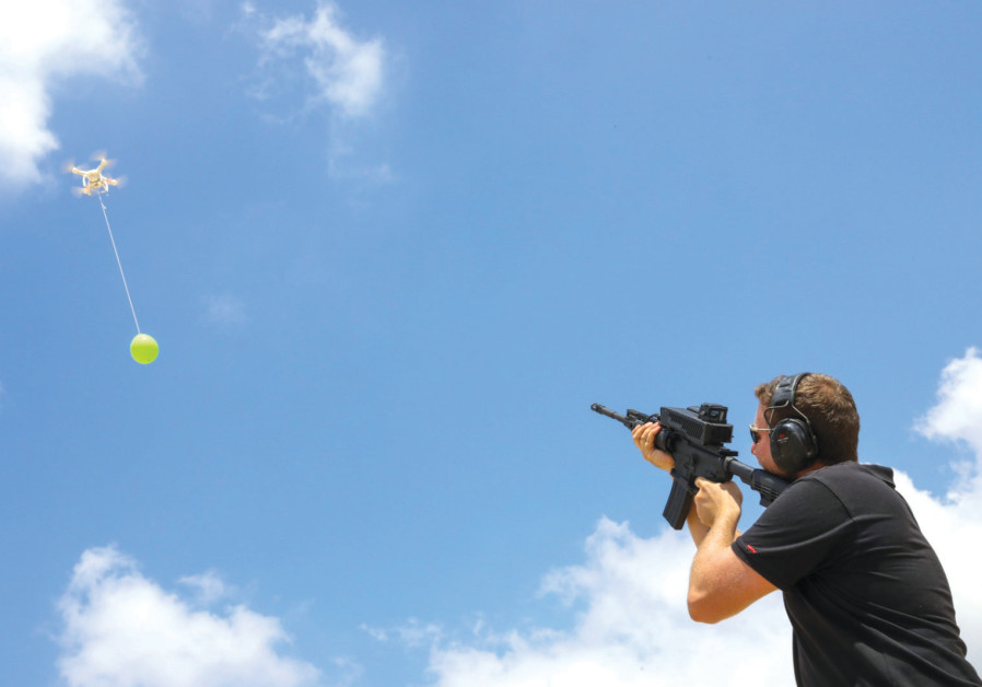 UN OPÉRATEUR montre comment SMASH agit contre un ballon comme ceux envoyés de Gaza en Israël. 